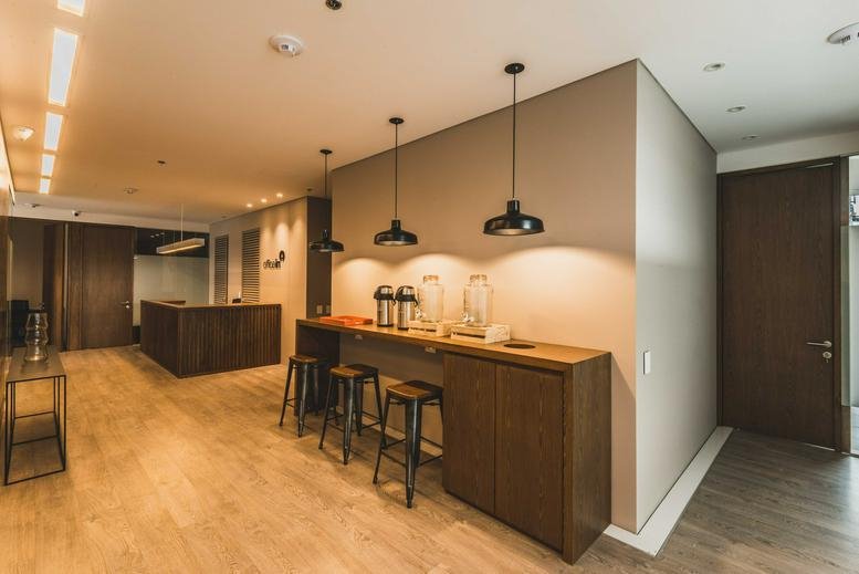 Spacious reception lounge at Calle 95 No 14-45 Piso 5 featuring wood accents and warm pendant lighting.