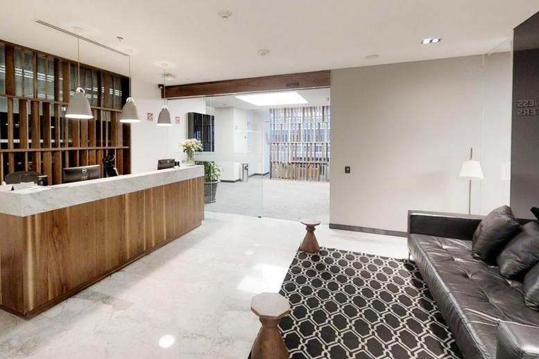Professional reception area with a wood-panelled desk and marble flooring.