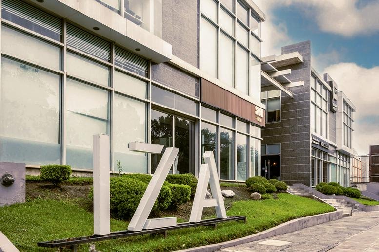 Exterior view of the modern glass and stone facade at IZA BC Calzada.