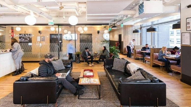 Spacious communal lounge at Campus Martius, 1001 Woodward Avenue with leather sofas and warm lighting.