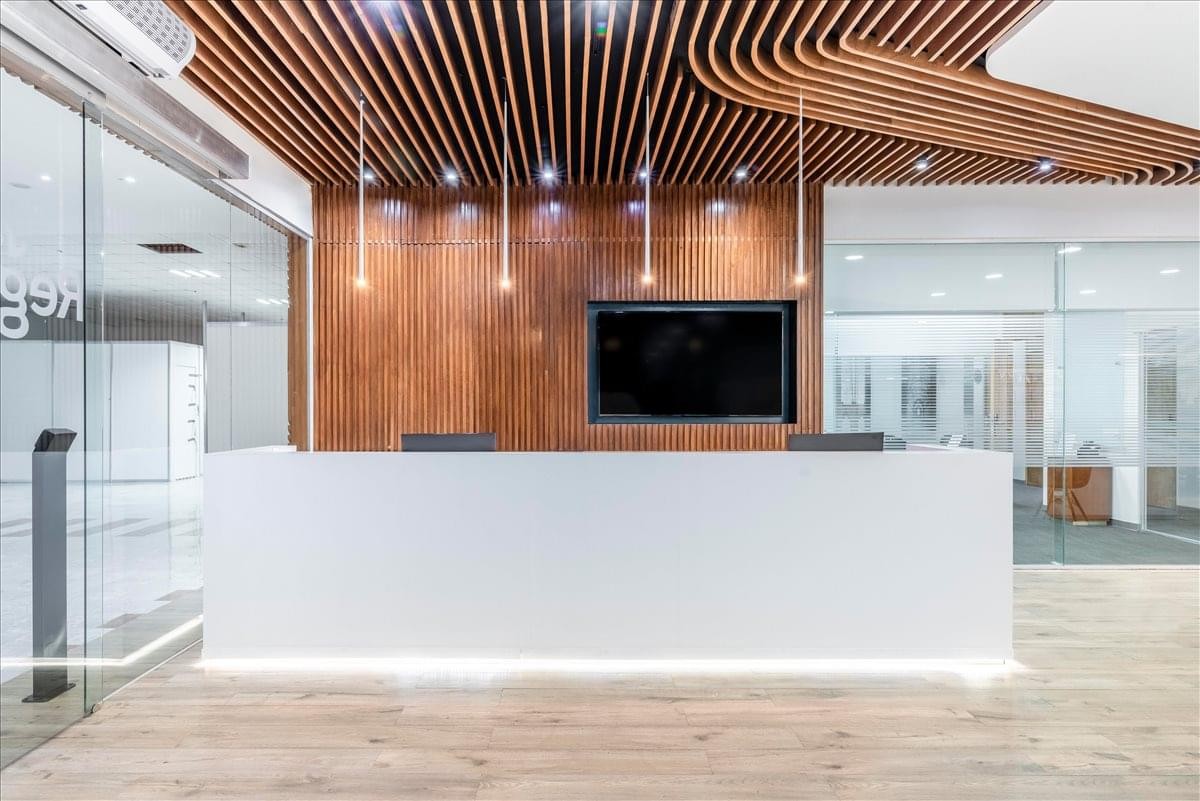 Modern reception desk at Cancun International Convention Center with wood-slat ceiling and warm lighting.
