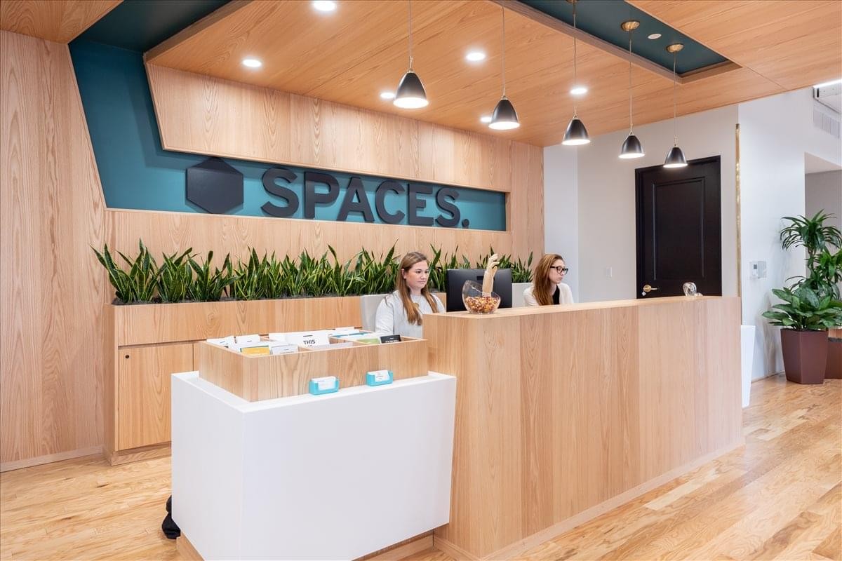 Modern wooden reception desk at Center City, 1326 Chestnut Street with branded signage and greenery.