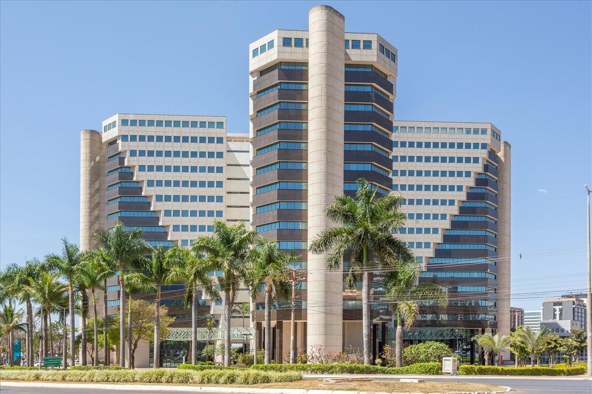 Exterior view of the tiered, modern architecture of Centro Empresarial Varig surrounded by palm trees.