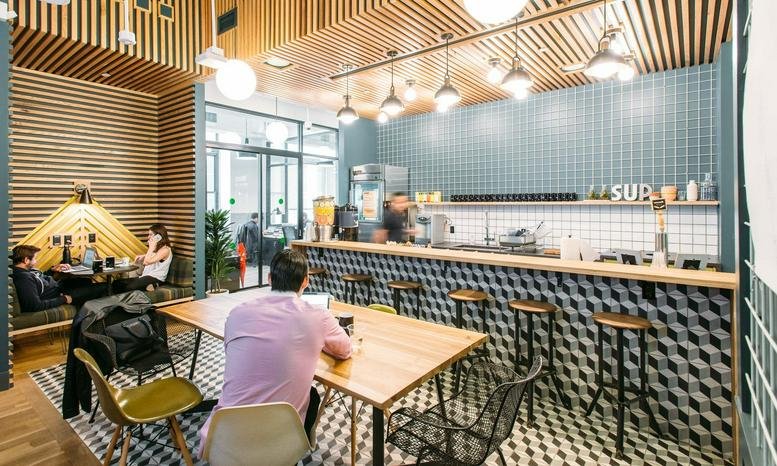 Spacious communal area at City Center, 1111 Broadway, Oakland, California with wood slat ceilings and a tiled cafe bar.