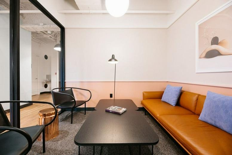 Lounge area with tan leather sofa and blue pillows at Colony Square, 1175 Peachtree Street NE.