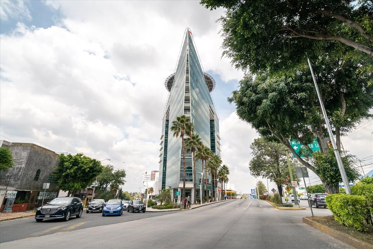 Modern glass skyscraper of the Conjunto Comercial Triangulo Las Animas with a pointed architectural peak.