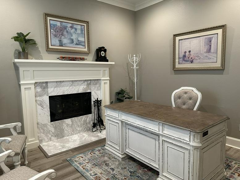 Private suite at Brownstone Office Condos, Longmire Road, Conroe featuring a fireplace and executive desk.