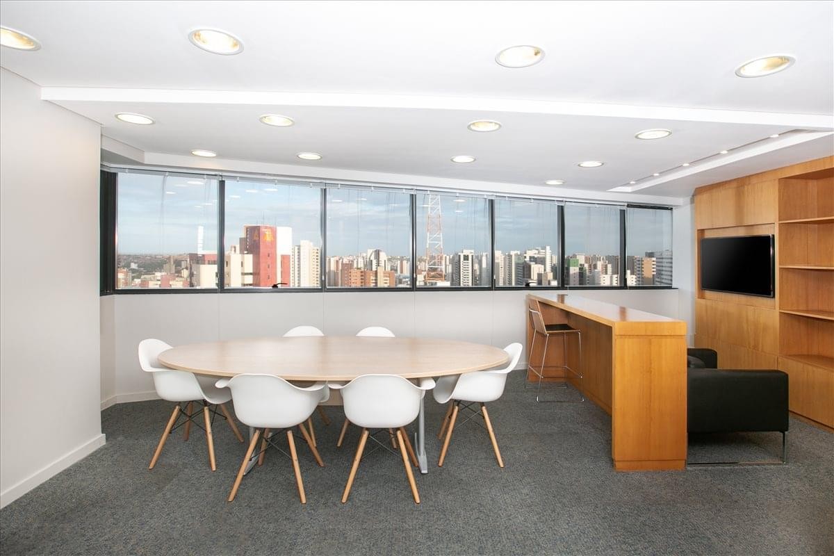Modern breakout area with a round dining table, breakfast bar, and lounge seating.