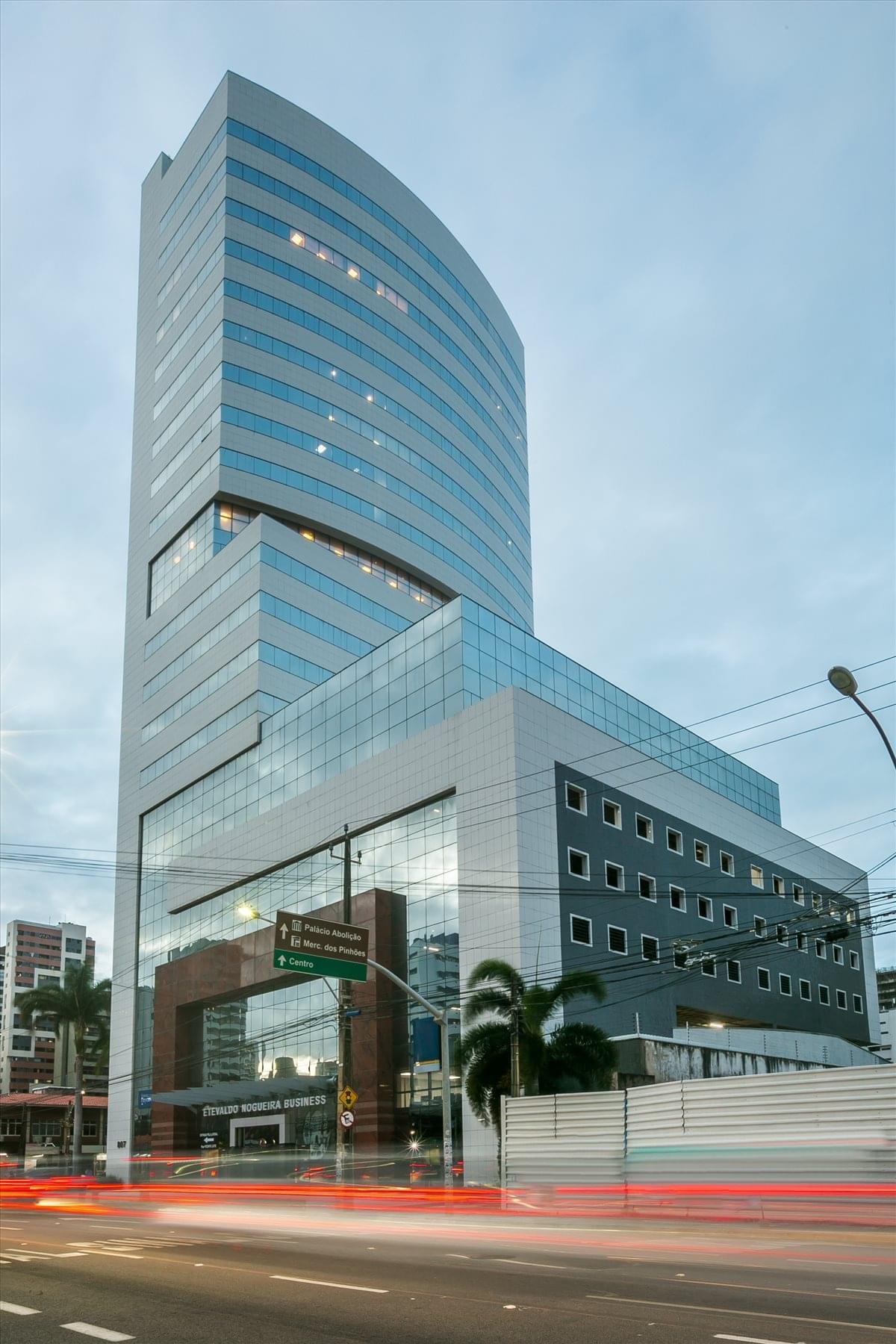Exterior view of the glass-facade 807 Avenue Dom Luis building at dusk.