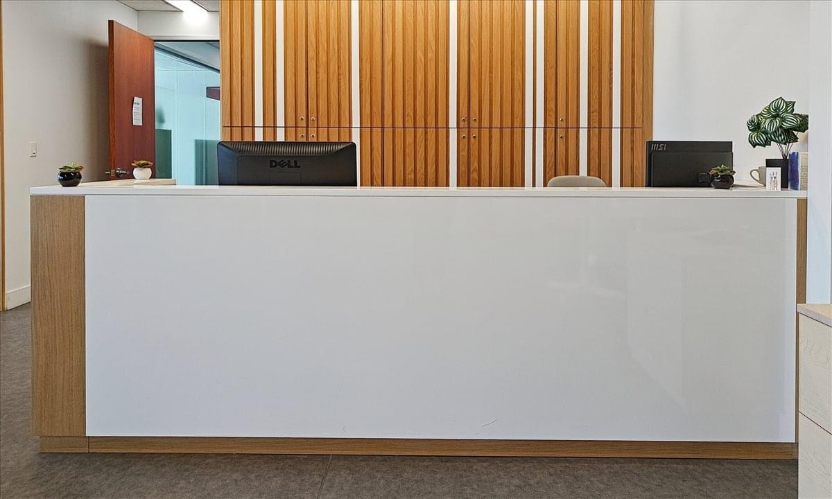 Front view of a minimalist white reception desk at 1 Dundas Street West, Suite 2500, Eaton Centre.