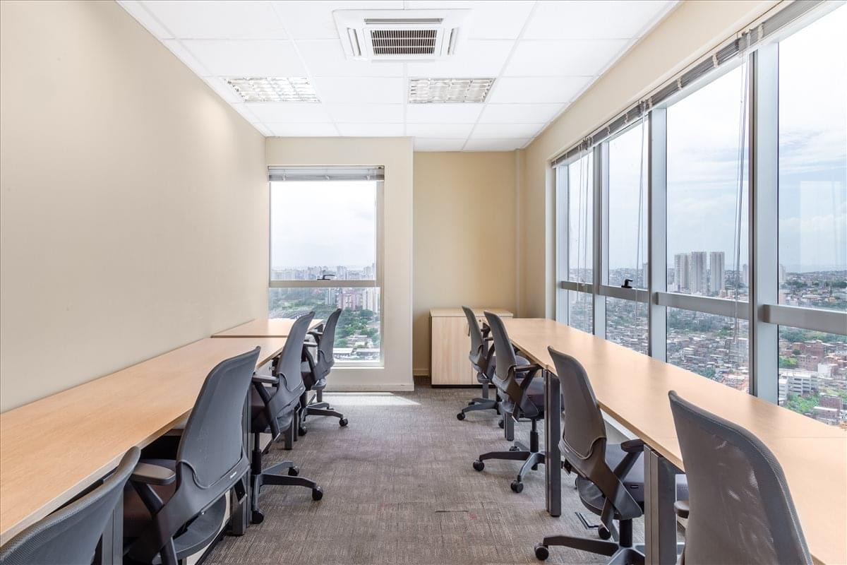 Spacious open-plan workspace at Edificio Mundo Plaza with long desks and panoramic city views.