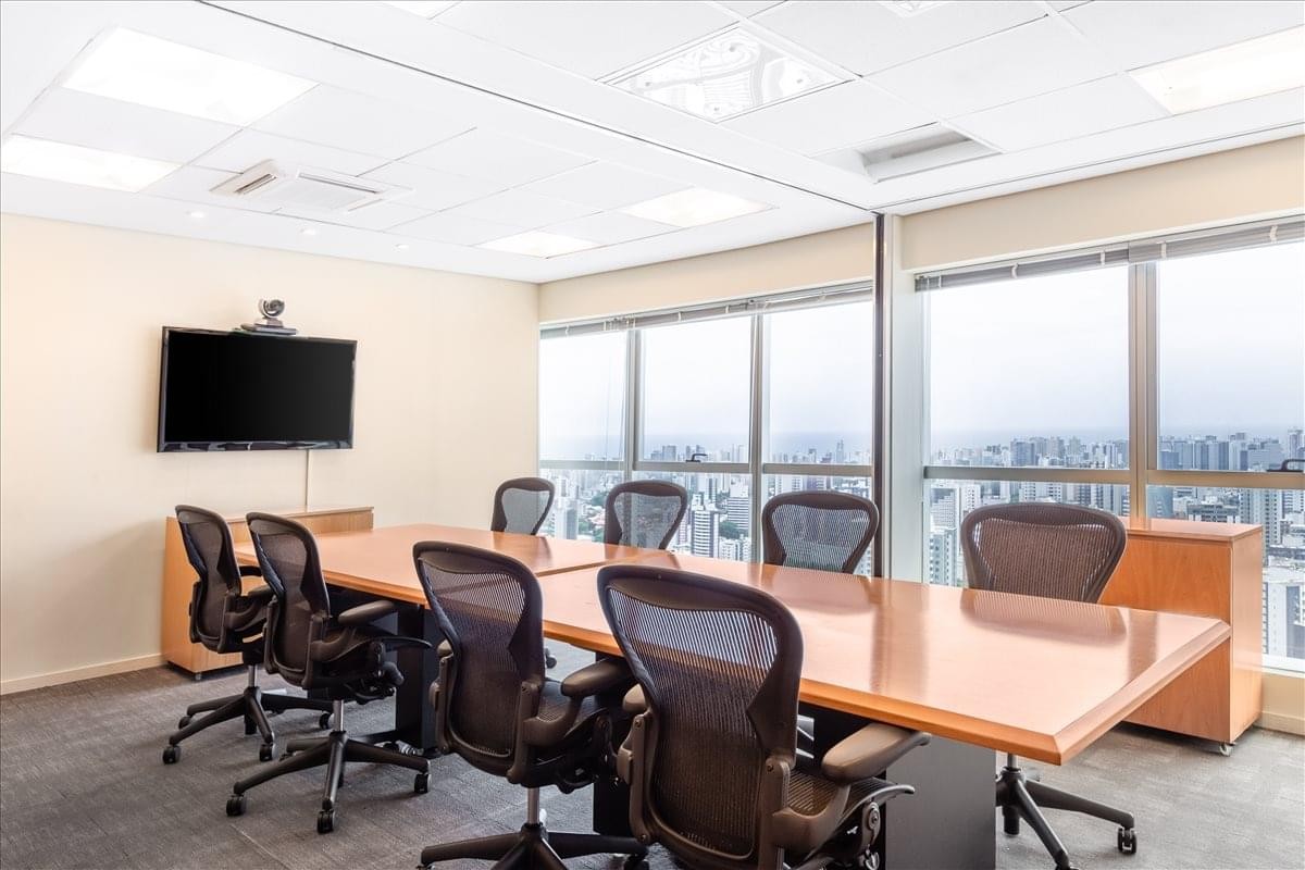 Modern conference room at Edificio Mundo Plaza featuring a large wood table and city views.
