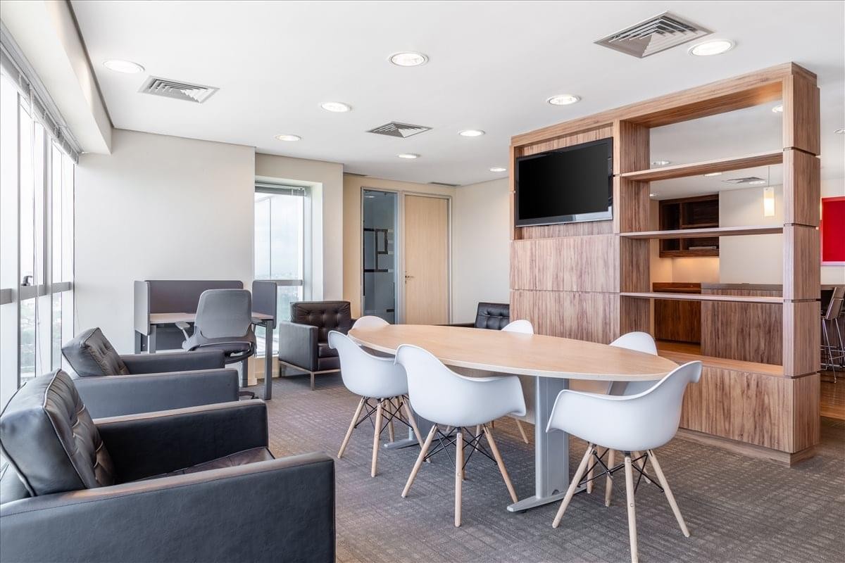 Lounge area with grey armchairs and a modern oval table at Edificio Mundo Plaza.