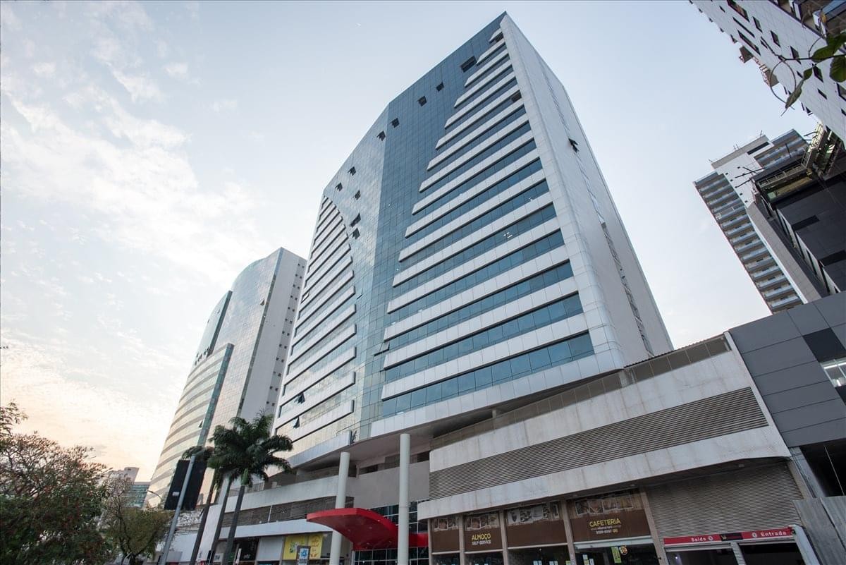 Exterior view of the glass-facade Edificio Work Center tower against a bright sky.