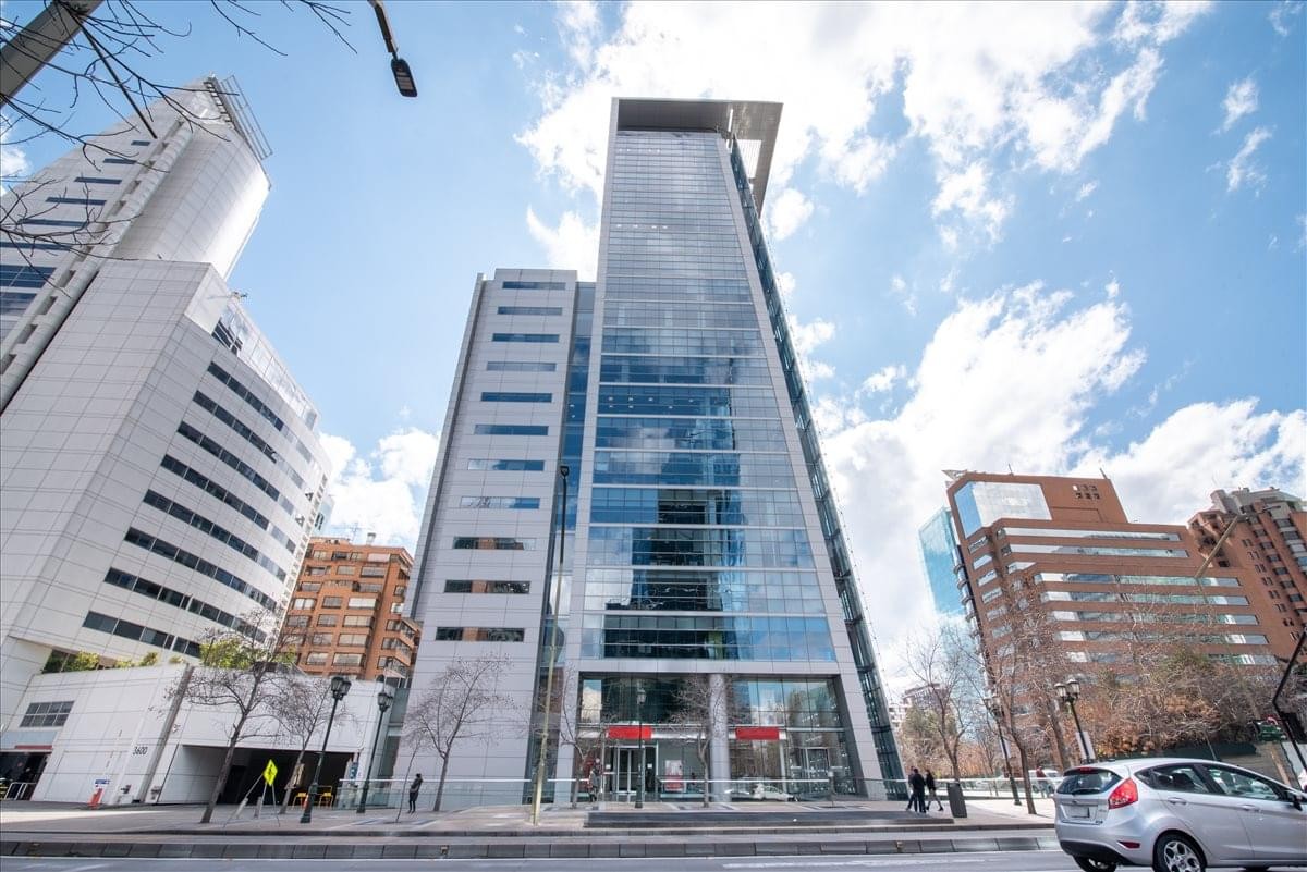 Exterior view of the glass-facade El Golf 40 building under a blue sky.