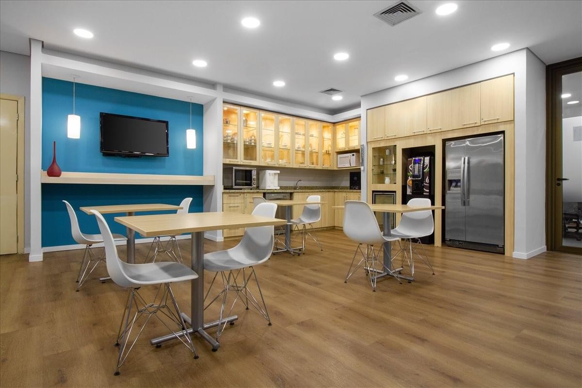 Modern breakroom at Av. Brigadeiro Faria Lima, 3729 featuring a blue accent wall and full kitchen.