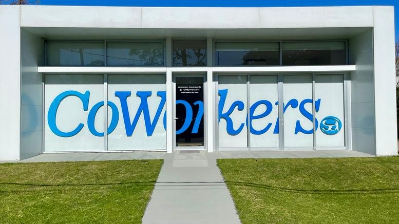 Exterior view of the CoWorkers office building with large branded glass frontage and a central walkway.