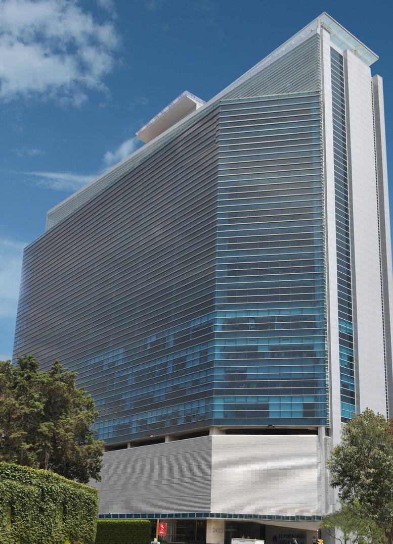 Exterior view of the modern glass-facade building at Insurgentes Sur 2453, Mexico City.