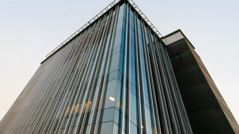 Modern glass exterior of the Insurgentes Sur 601 office building against a clear sky.