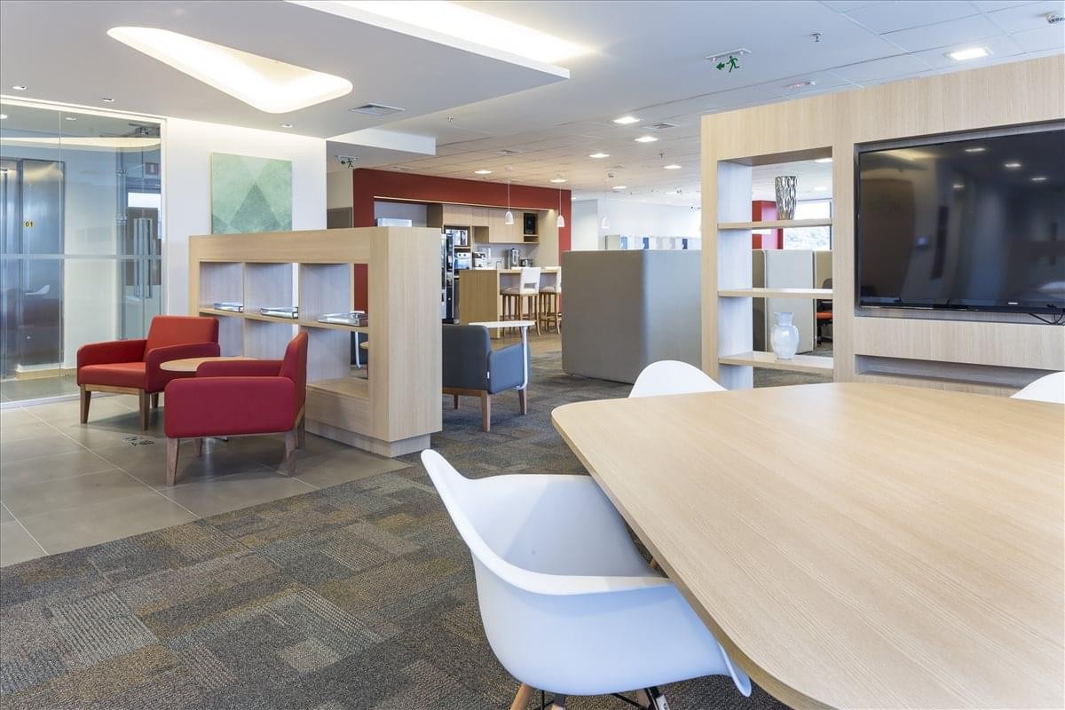 Spacious communal lounge at JK Complex, Tower B featuring red armchairs and wood accents.