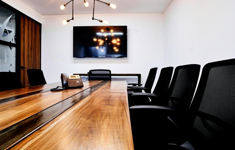 Spacious boardroom with a long wood table and modern lighting at Kenex Plaza, 9th Floor.