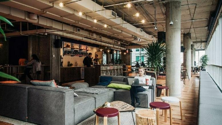 Spacious communal lounge at L’Avenue, 1275 Avenue des Canadiens with modular seating and industrial ceilings.