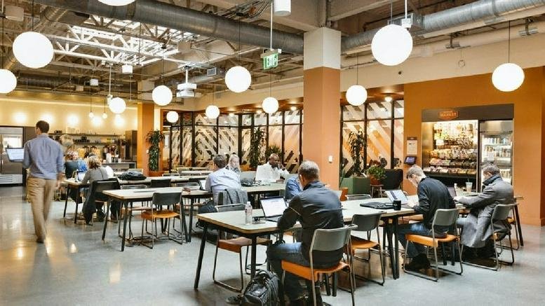 Spacious open-plan coworking area at Legacy West, 7400 Windrose, Plano, Texas with industrial ceilings and globe lights.
