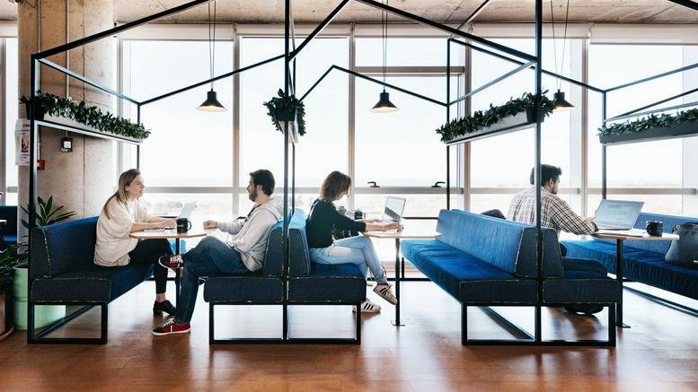Spacious communal lounge at Libertador 1000 with blue velvet booths and decorative metal house frames.