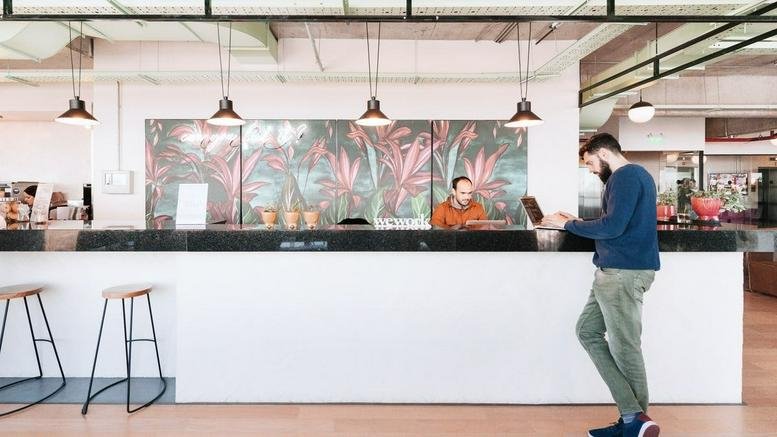 Modern reception desk at Libertador 1000, Vicente Lopez, Buenos Aires, Argentina with hanging industrial lamps.