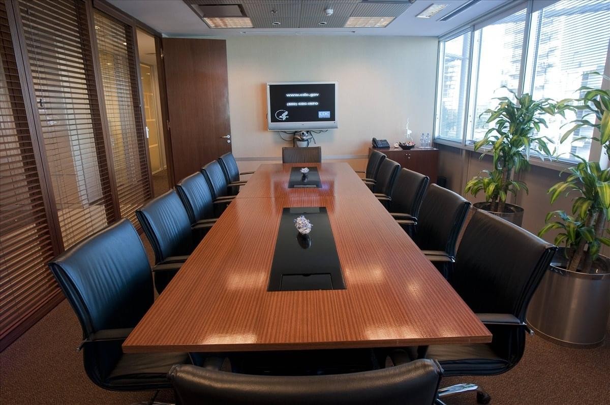 Spacious boardroom with a large wooden table and wall-mounted monitor at Libertador Avenue 2442.