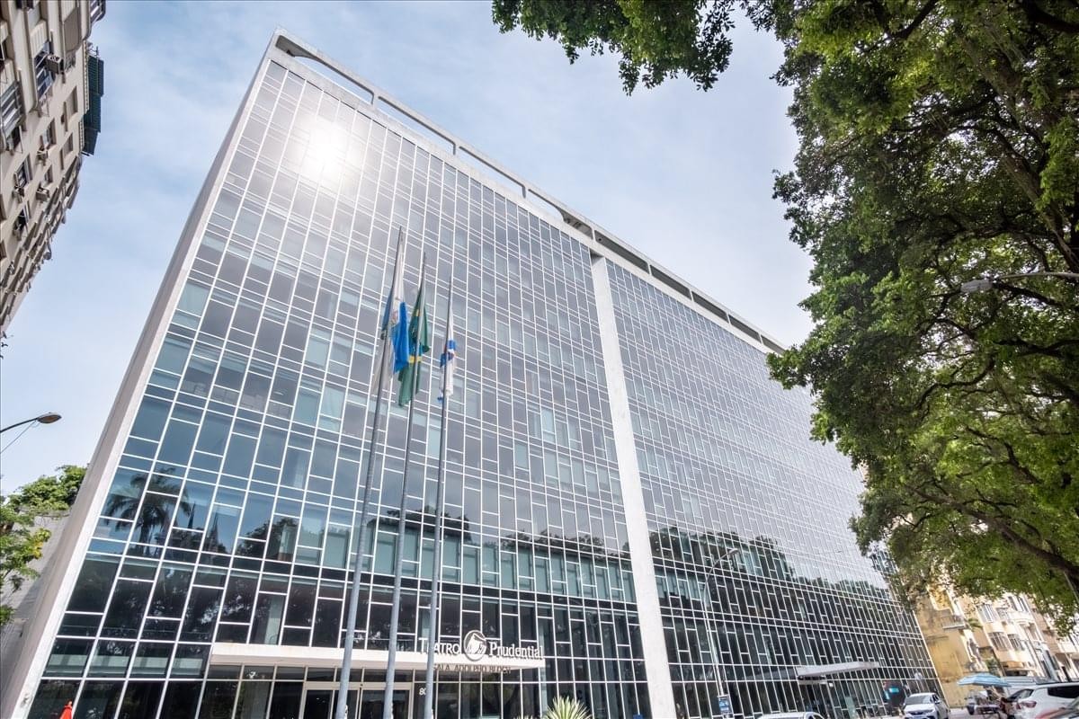 Exterior view of the glass-facade Machete Building 804 with surrounding green trees.