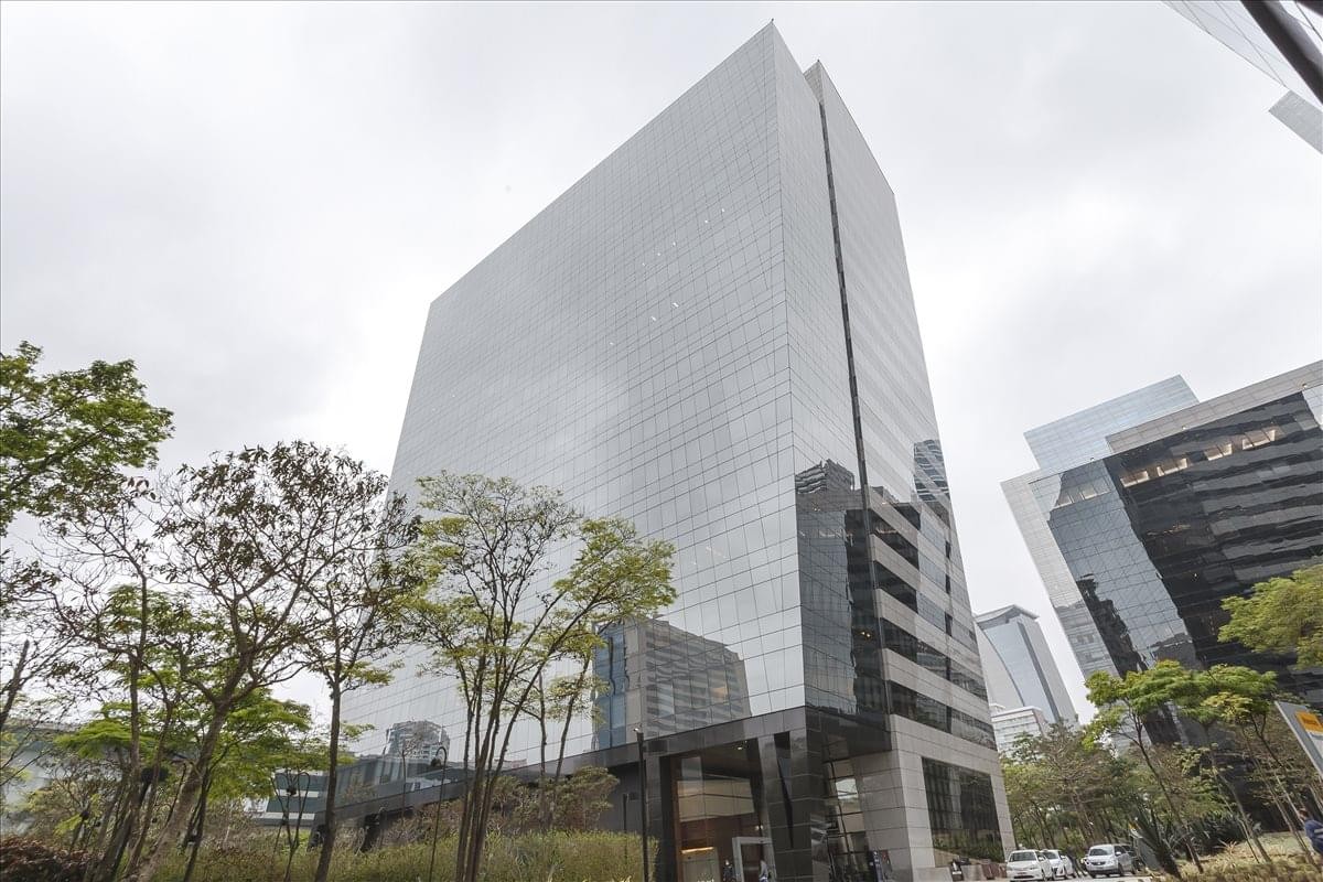 Exterior view of the glass-facade Marble Tower showing the high-rise structure and surrounding trees.