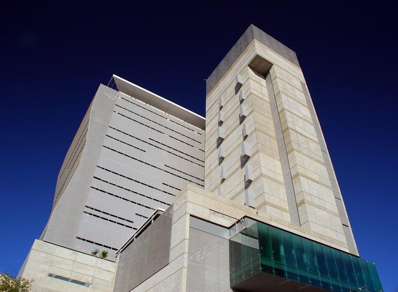 Modern stone facade with blue glass accents at Misión de San Javier 10643.
