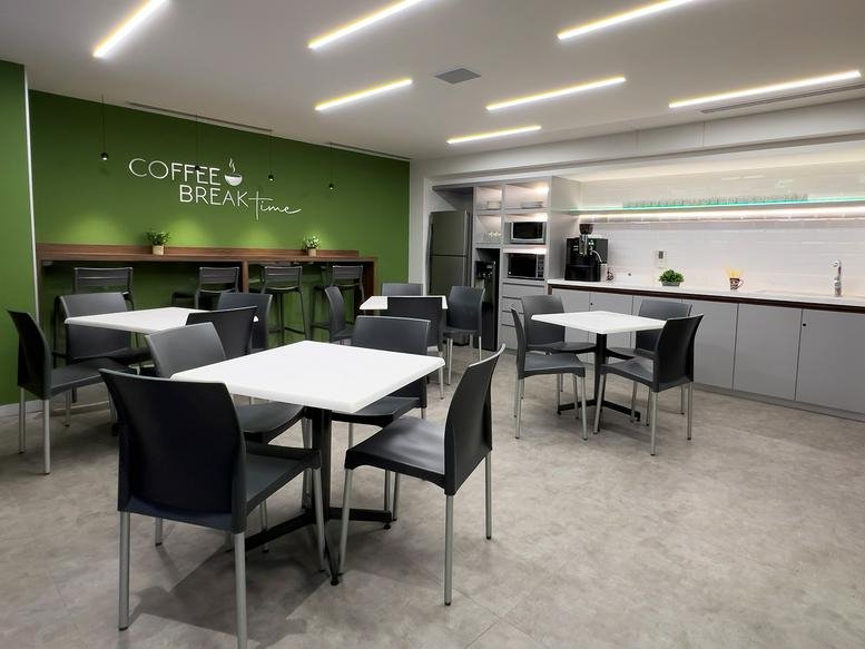 Spacious coffee break area at Monte Elbruz No. 124, featuring a green feature wall and dining tables.
