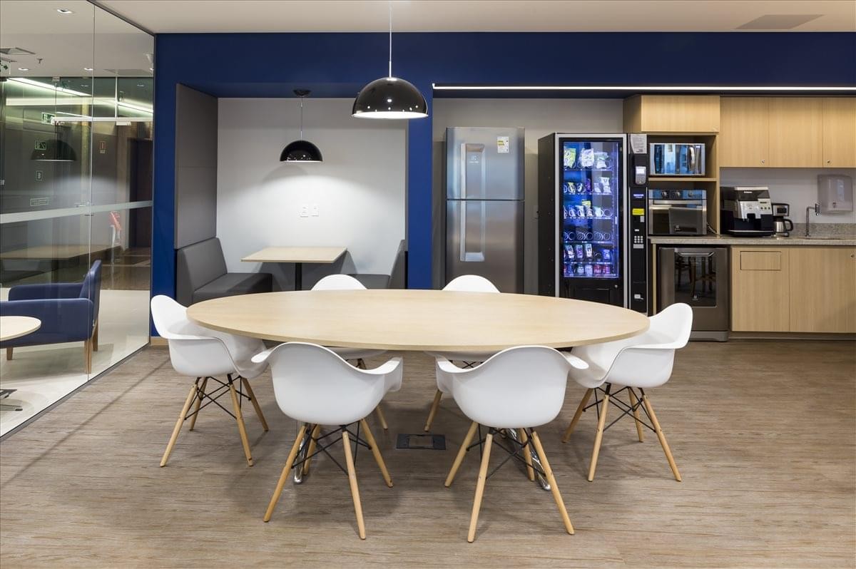Spacious communal dining area at Nacoes Unidas Tower with a large oval table and modern kitchen.