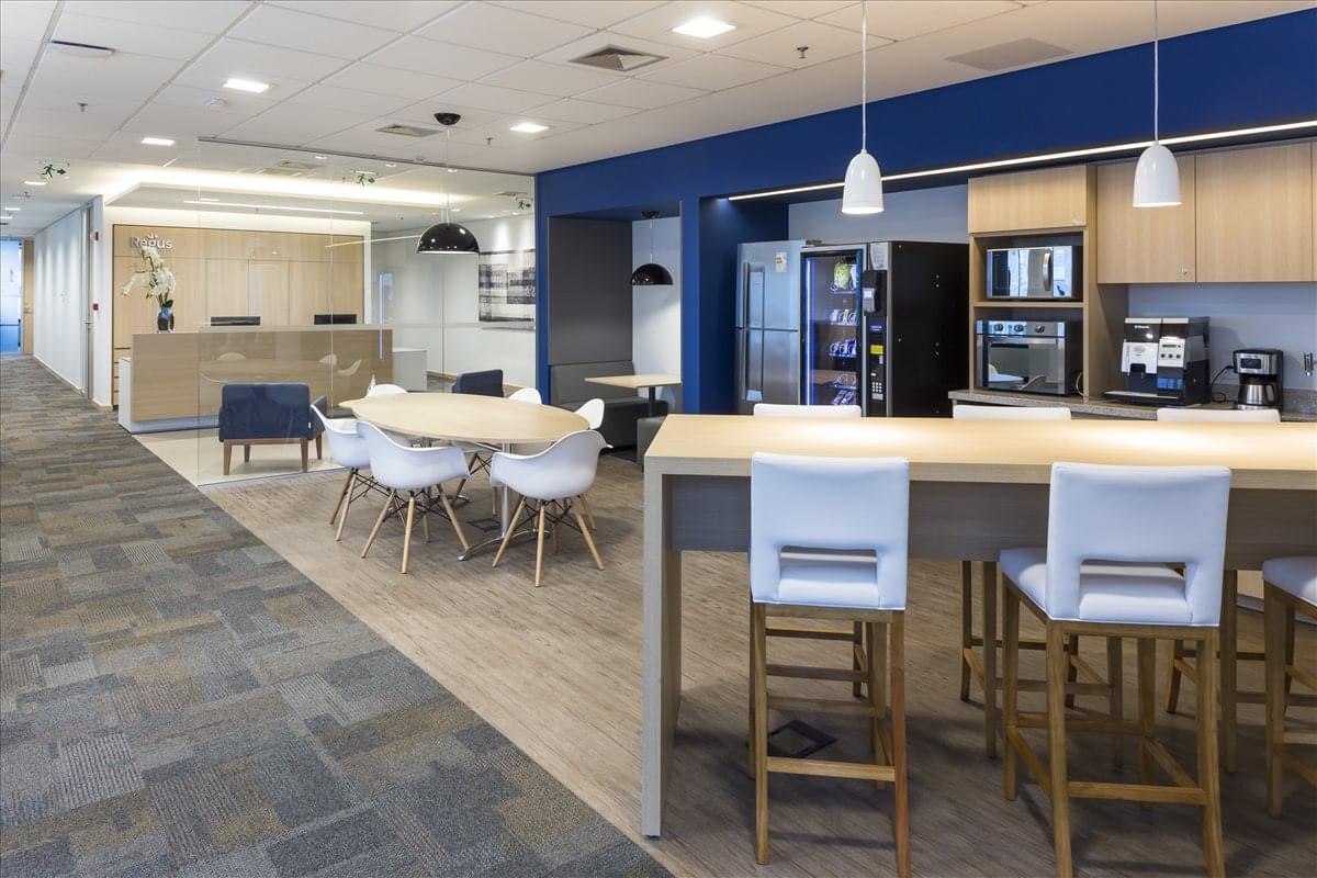 Spacious reception area at Nacoes Unidas Tower featuring a light wood desk and blue accent chairs.