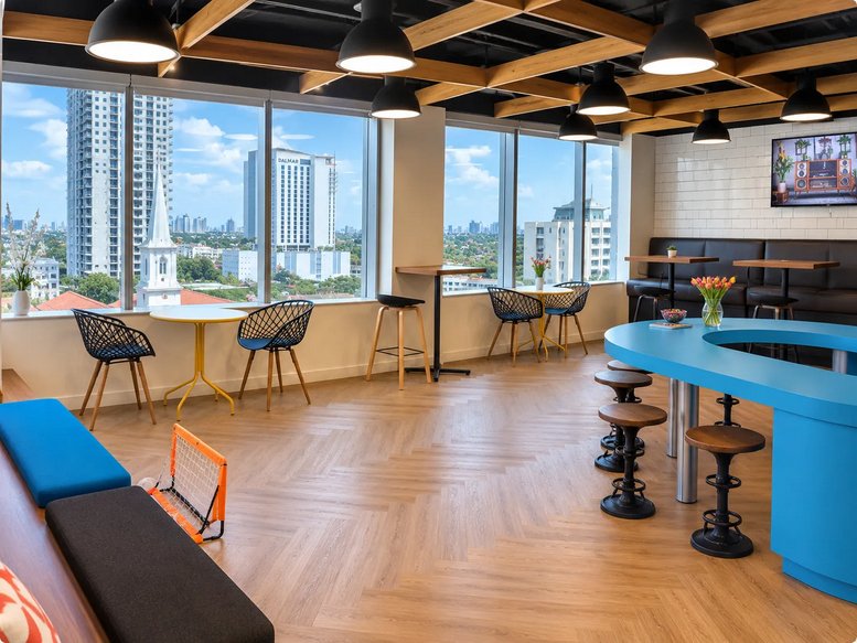Modern communal lounge at One Financial Plaza, 100 Southeast Third Avenue with blue accents and city views.