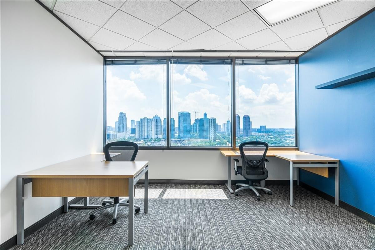 Spacious private office with large windows overlooking the city skyline at One Riverway.