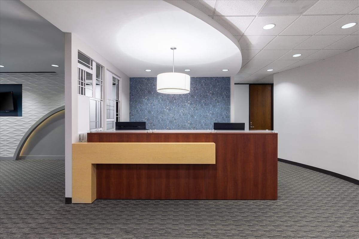 Professional reception area for One Riverway, Suite 1700, featuring a sleek wood and tan front desk.