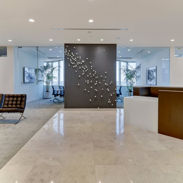 Sleek reception area with a marble floor, feature wall with art, and warm lighting.