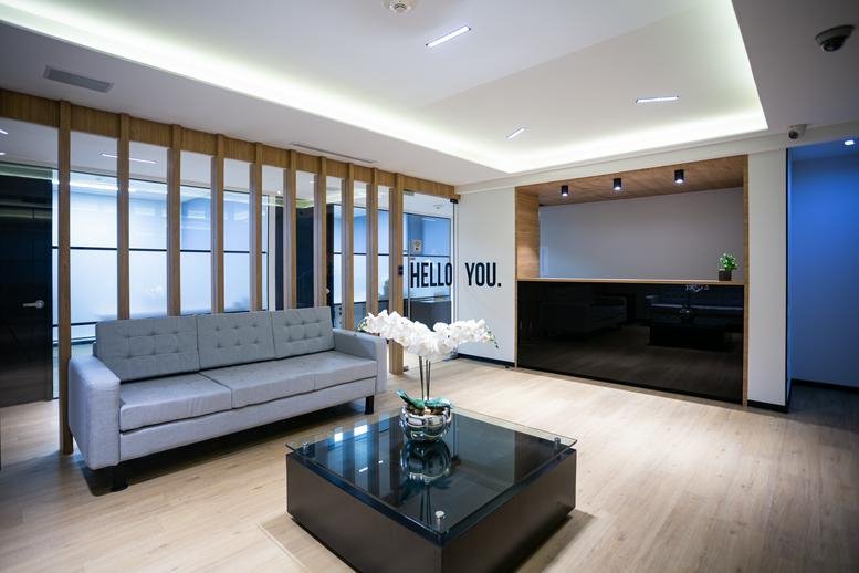 Reception area at Pafnuncio Padilla 26, Piso 3, Ciudad Satélite featuring a grey sofa and black desk.
