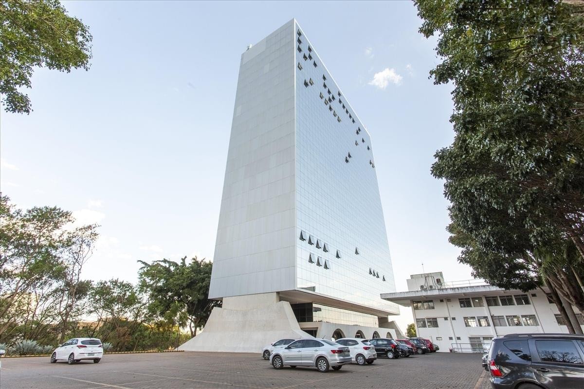 Sleek exterior facade of the Palacio da Agricultura Building with glass reflections and modern concrete base.