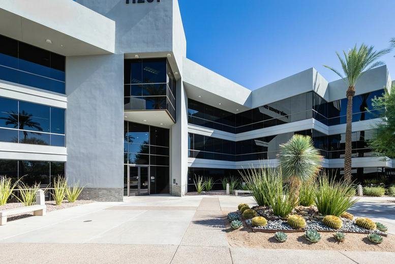 Modern exterior of 11201 North Tatum Boulevard, Phoenix, featuring a gray facade and desert landscaping.