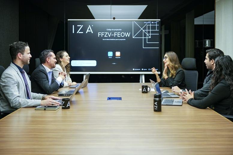 Modern boardroom with a large screen and people having a collaborative discussion.