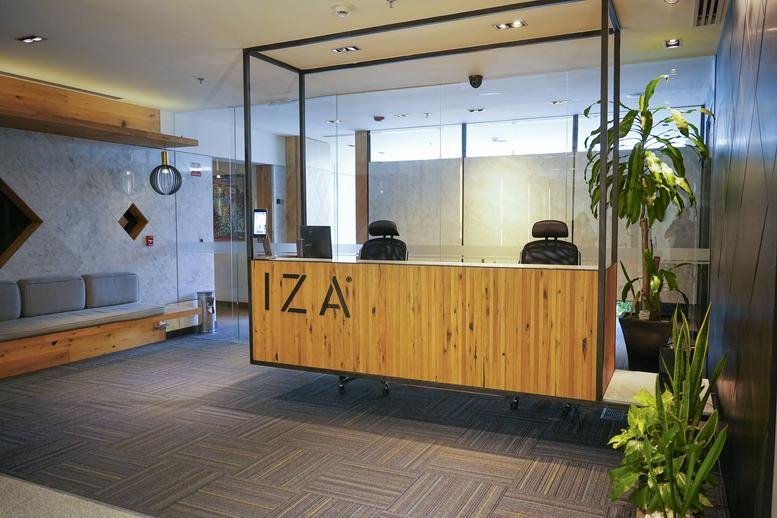 Modern reception area featuring a warm wooden front desk and indoor plants.