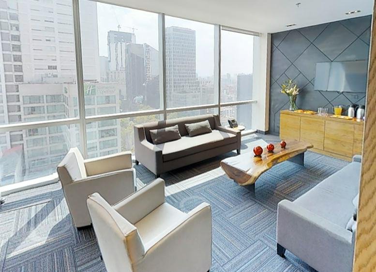 Spacious lounge area with grey armchairs and a live-edge wooden coffee table.