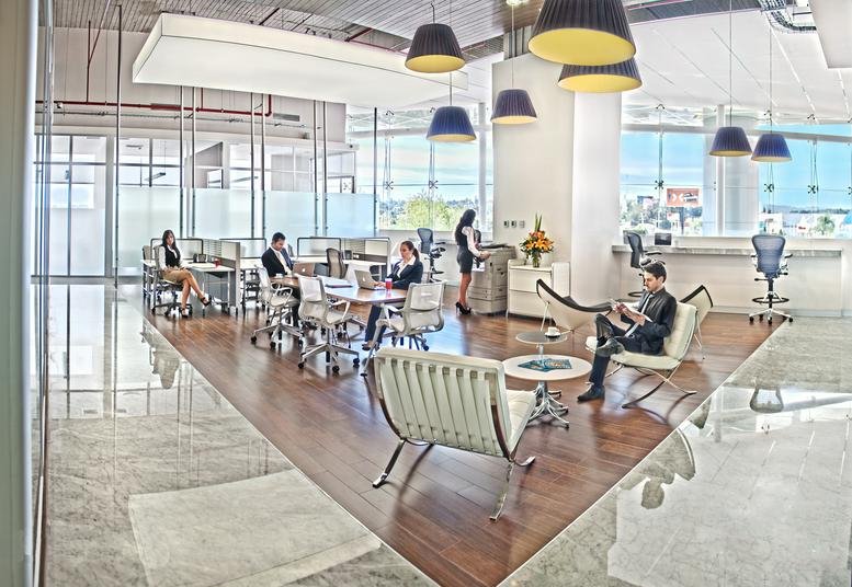 Spacious communal breakout area with diverse seating options and large windows.