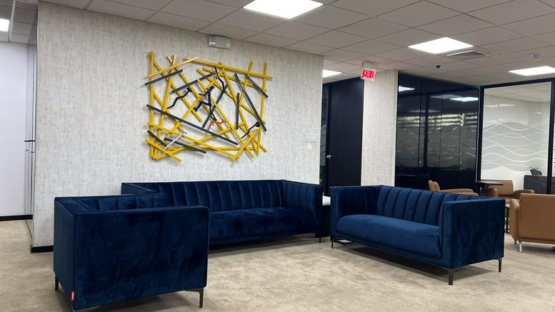 Reception area at PH Plaza Canaima featuring navy blue velvet seating and abstract wall art.