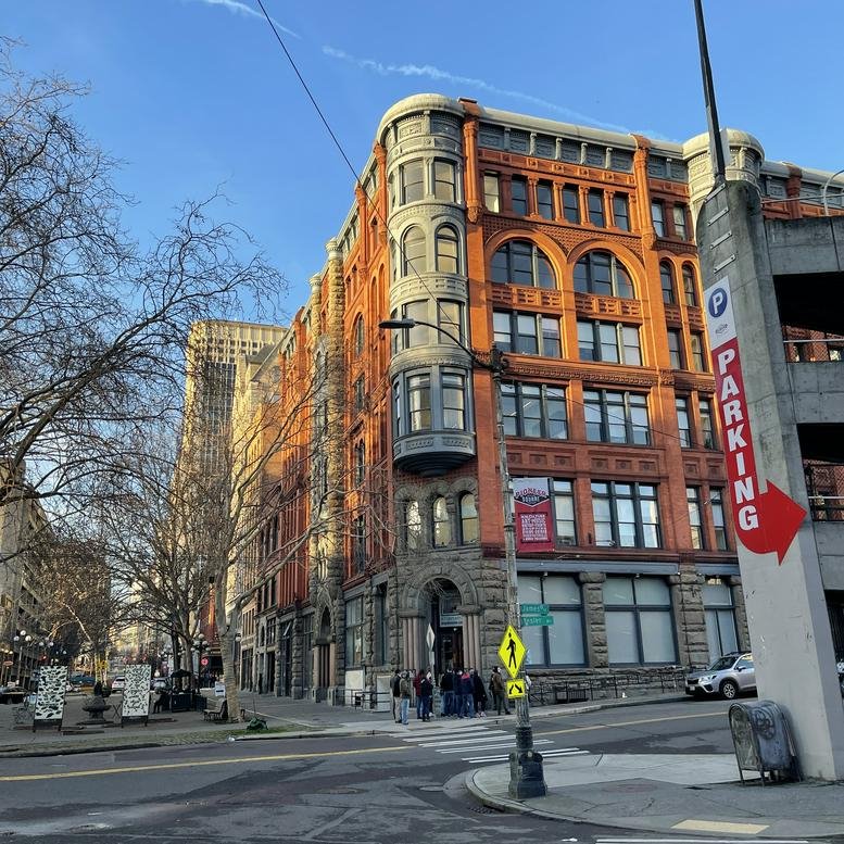 Exterior view of the historic red brick Pioneer Building with ornate architectural details.