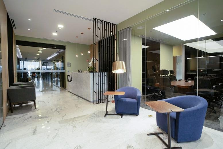 Modern lobby with marble floors and blue velvet armchairs.